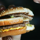 Woman biting into McDouble from McDonald's